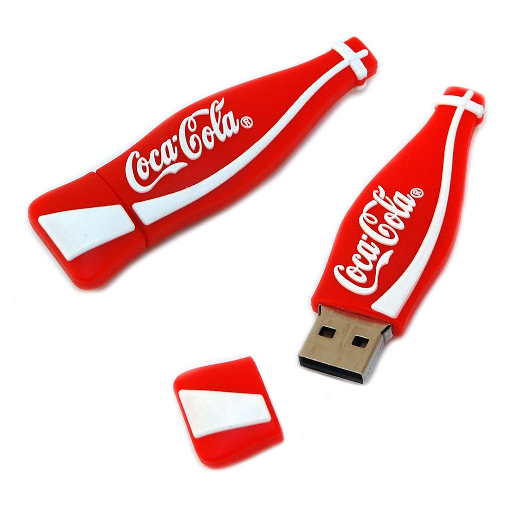 Memoria USB con forma de botella Coca-Cola, fabricada en rubber. De medidas 70x20x11mm aprox. Capacidad 4 GB. Sin información grabada en su interior. Incluye personalización de logo Coca-Cola a un color en dos posiciones. Presentado en caja blanca individual.